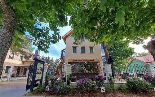 a house with a clock on the front of it at Guest House & Villa Astoma in Palanga