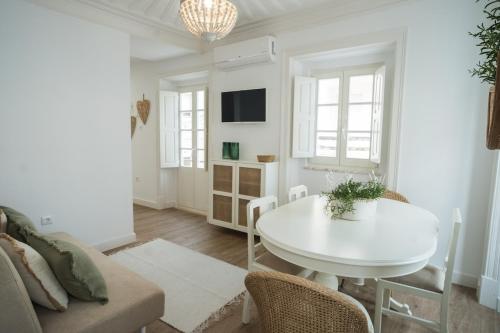 een woonkamer met een witte tafel en een bank bij The Bird House in Nazaré