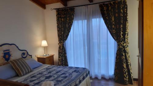a bedroom with a bed and a large window at Casa Logos Stintino - Private pool in Stintino