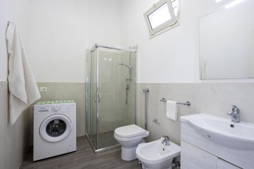 a bathroom with a toilet sink and a washing machine at La Perla Di Mare - Gemma in Mazara del Vallo
