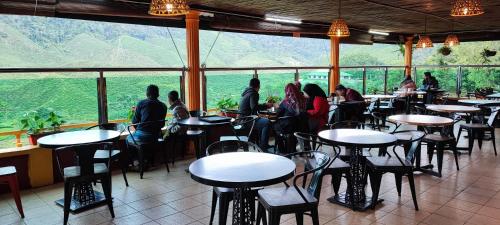 a group of people sitting at tables in a restaurant at Tekoma Resort Cameron Highlands in Tanah Rata