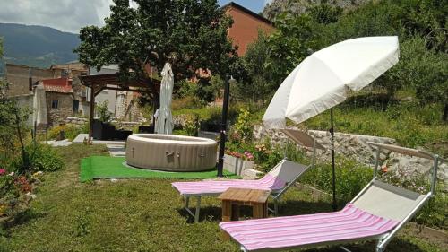ein paar Stühle, ein Regenschirm und ein Brunnen in der Unterkunft Borgo del Sole in Foglianise