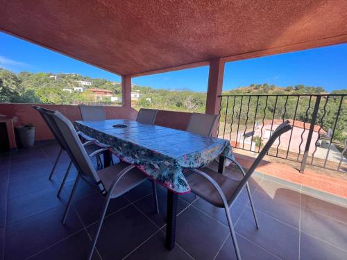 a table and chairs on a balcony with a view at residence Catalani in Zonza