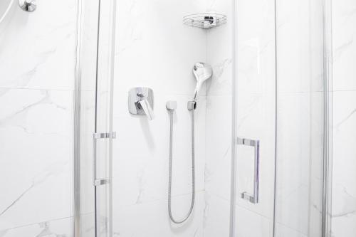 La salle de bains est pourvue d'une douche et d'une porte en verre. dans l'établissement Etoile City Center Apartments, à Belgrade