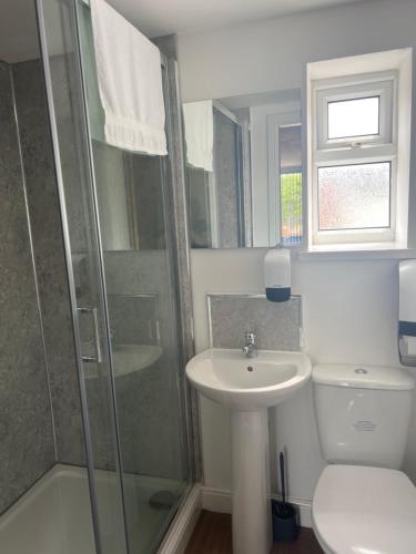 a bathroom with a toilet and a sink and a shower at City apartments college street in Hull