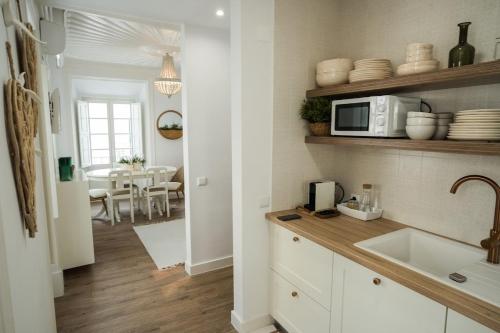 een keuken met een spoelbak en een magnetron bij The Bird House in Nazaré