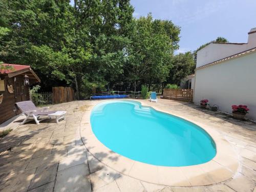 uma grande piscina azul num quintal em MAISON OROUET PISCINE 4 CHAMBRES em Saint-Jean-de-Monts