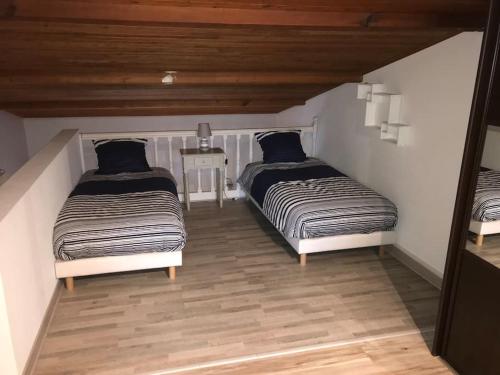 two beds sitting in a room with at Maison familiale au cœur du bassin d'Arcachon in Biganos