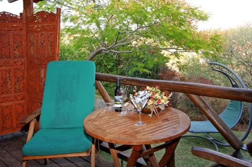 a table with two chairs and a bottle of wine at Rosh Pinat Noy in Rosh Pinna