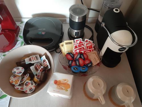 una mesa con dos cuencos de galletas y una cafetera en Il Glicine B&b, en Voltaggio