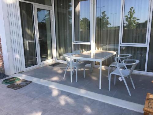 een patio met een tafel en stoelen op een balkon bij New and modern apartment in the city center in Maastricht