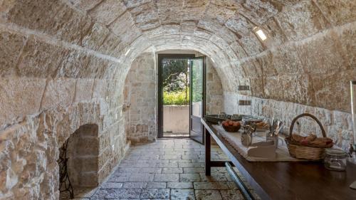a stone walled kitchen with a counter and a stone fireplace at MASSERIA TARSIA INCURIA 8&4, Emma Villas in Conversano
