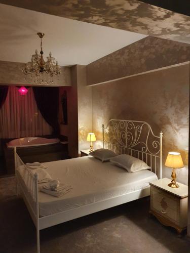 a bedroom with a white bed and a chandelier at Studio Rendez-vous Alba Iulia in Bucharest