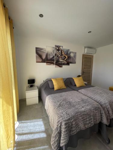 a bedroom with a bed with yellow pillows at Les pins du Luberon in Coustellet
