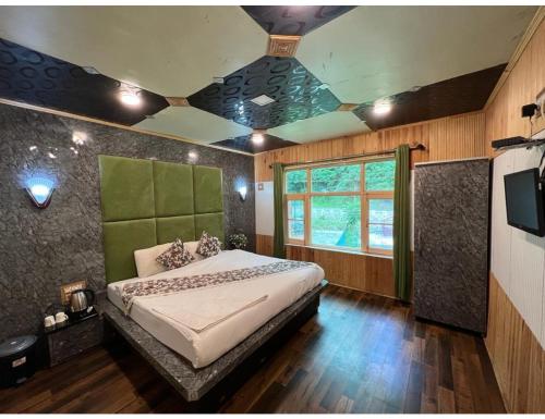a bedroom with a bed and a tv in it at Grand Mala Resorts, Pahalgam in Pahalgām