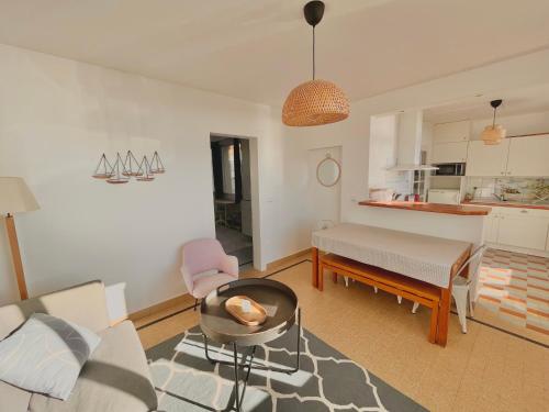 a living room with a couch and a table at La Maison - Ambleteuse - Vue sur Mer et Jardin in Ambleteuse
