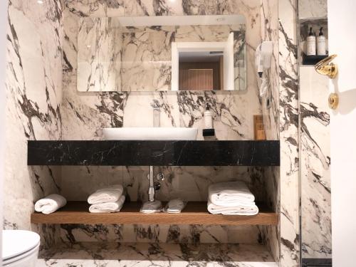 地拉那的住宿－Marinaj Hotel，一间带水槽和镜子的浴室