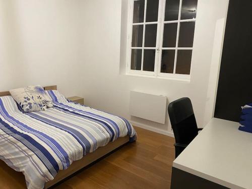 a bedroom with a bed and a desk and a window at Logement 10 min des sanctuaires in Paray-le-Monial