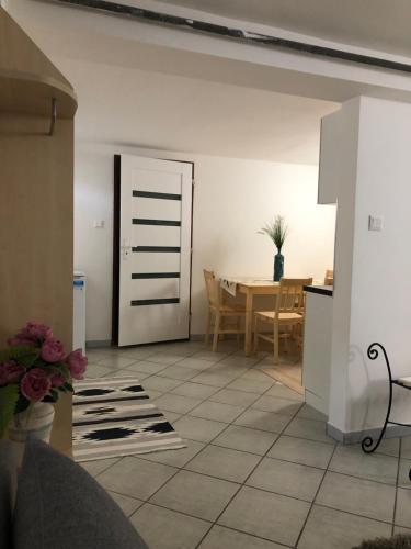 eine Küche und ein Esszimmer mit einem Tisch und einer Tür in der Unterkunft Villa Marta in Štúrovo