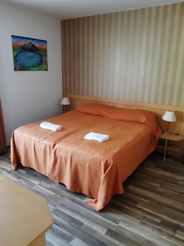 a bedroom with a bed with two towels on it at SpaRelax Apartman Zalakaros in Zalakaros