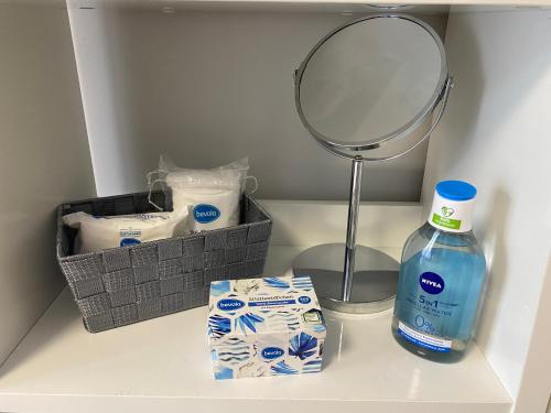 a shelf with a mirror and a bottle of detergent at Iva Luxury Apartament in Ruse