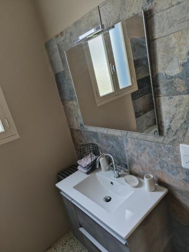 une salle de bain avec un lavabo et un miroir dans l'établissement A l'ombre de l'olivier, à Orgon