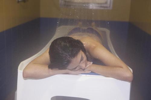 a woman is laying in a bath tub at Hotel Balneario de la Concepción in Villatoya
