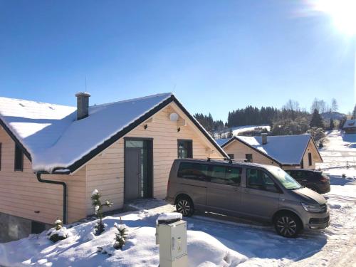 a van parked in front of a house in the snow at Mountain Houses Kubínska hoľa in Dolný Kubín