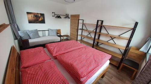 two beds in a room with a couch and shelves at Mountain Houses Kubínska hoľa in Dolný Kubín