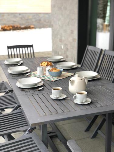 a wooden table with plates and cups on it at Mountain Houses Kubínska hoľa in Dolný Kubín