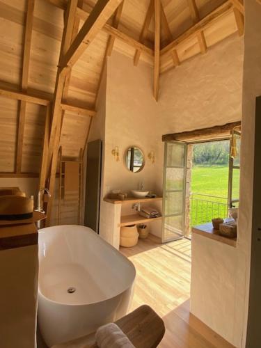 a large bathroom with a large white bath tub at Le Mas de Laval in Saint-Cirq-Lapopie