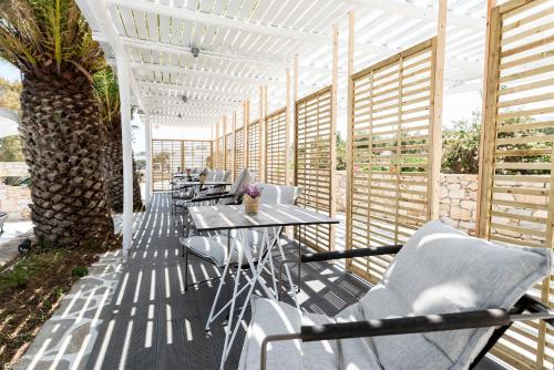 una fila de mesas y sillas en un patio en Pnoi Hotel, en Logaras
