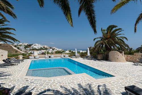 - une piscine bordée de chaises et de palmiers dans l'établissement Pnoi Hotel, à Logaras