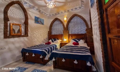 a bedroom with two beds with blue and white sheets at Casa Meftah Blue in Chefchaouene