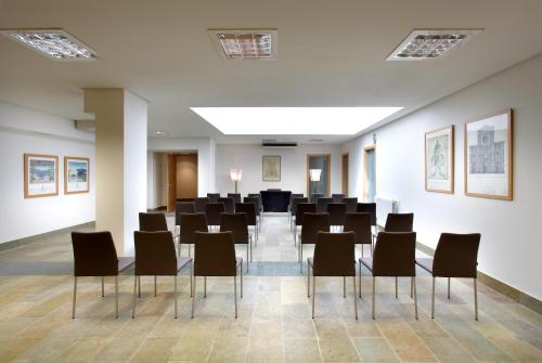 a large room with chairs and paintings on the walls at Exe Casa de Los Linajes in Segovia