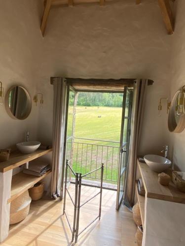 a bathroom with two sinks and a sliding glass door at Le Mas de Laval in Saint-Cirq-Lapopie