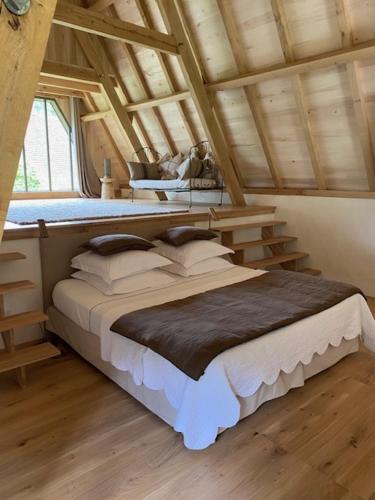 a bedroom with a large bed in a attic at Le Mas de Laval in Saint-Cirq-Lapopie