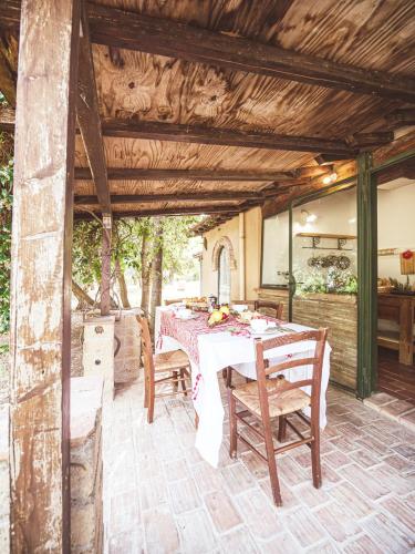 an outdoor dining room with a table and chairs at Relais Casale Il Poggetto - I PINI by Zoom In Earth in Cecina