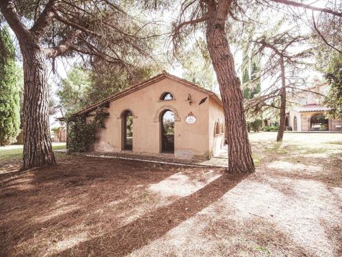 a small building with two trees in front of it at Relais Casale Il Poggetto - I PINI by Zoom In Earth in Cecina