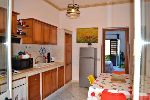 a kitchen with a table and a refrigerator at Happie Casa Stazione Centrale in Palermo