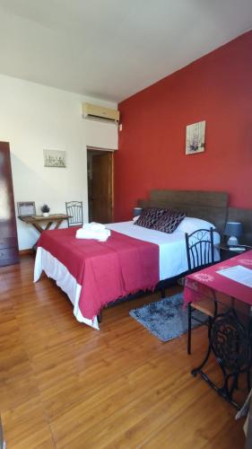 a bedroom with two beds and a red wall at Posada Don Manuel in Santa Isabel