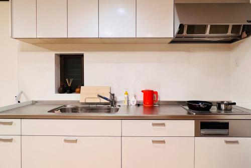 a kitchen with white cabinets and a sink at 東寺楽屋 Toji Rakuya in Kyoto