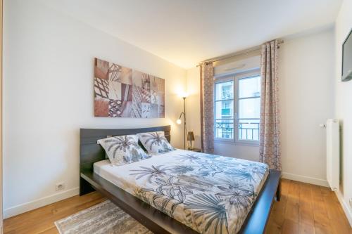 庫爾布瓦的住宿－Havre de paix - Appt avec terrasse，一间卧室设有一张床和一个窗口