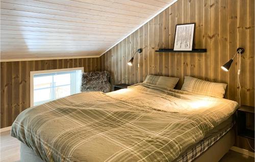 un letto in una camera da letto con parete in legno di Cozy Home In Nordfjordeid With Wifi a Nordfjordeid