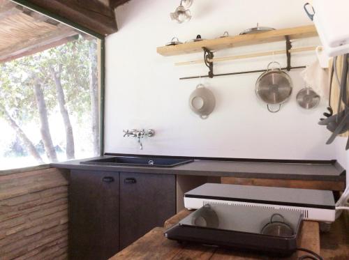 a kitchen with a counter and a sink and a window at Relais Casale Il Poggetto - I PINI by Zoom In Earth in Cecina