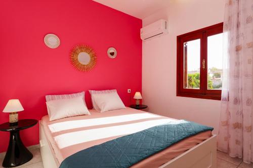 a bedroom with a red wall and a bed at Entire vacation house near beach in Gournes