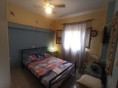 sypialnia z łóżkiem i oknem z zasłoną w obiekcie Vangel Garden w mieście Ajos Nikolaos