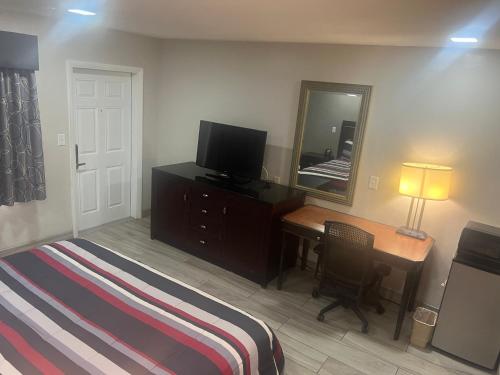 a bedroom with a bed and a desk and a mirror at Flamingo Inn in Sarasota