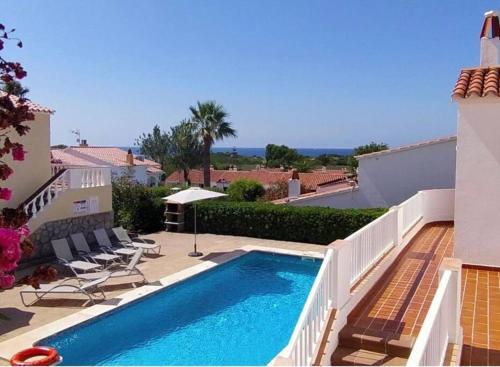 een zwembad aan de zijkant van een huis bij 3 Bedroom Villa, San Jaime, Son Bou in Son Bou