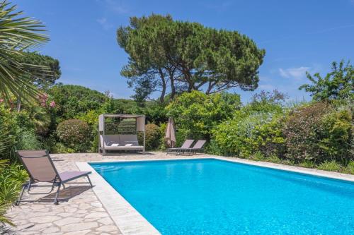 - une piscine avec 2 chaises longues et une balançoire dans l'établissement Villa Bohème, à Saint-Tropez